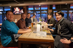 Smiling people sit together at a restaurant table.