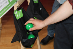 Participant places voting balls in one of the project bags