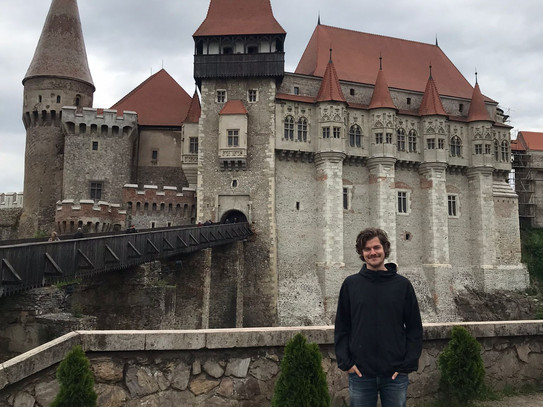 man standing in front of an old castle