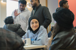 Eine internationale Studentin sitzt inmitten einer Gruppe von Menschen
