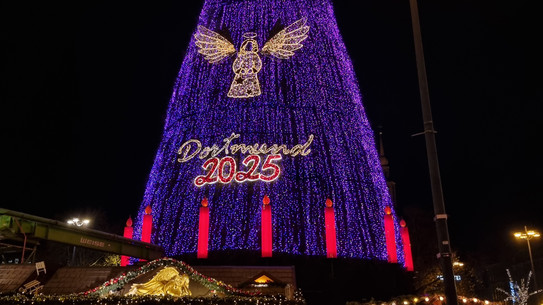Ein großer beleuchteter Weihnachtsbaum mit einem Engel und der Aufschrift Dortmund 2025.