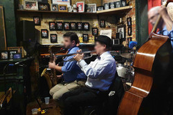 Eine kleine Jazzband, bestehend aus drei Personen, spielen Instrumente.
