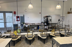 Ceramics Studio Das Bild zeigt einen studioartigen Raum mit kleinen Tischen und umgedrehten Stühlen.
