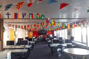 Ein Raum voller Schreibtische und Flaggen verschiedener Nationalitäten.