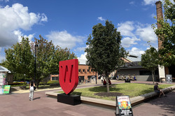 Blick auf einen Platz vor einem Gebäude - ein Logo der WWU im Riesenformat steht in der Mitte