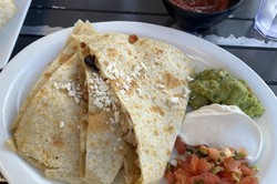 Enchiladas Teiggebäck mit Tomaten und Dips auf einem Teller.