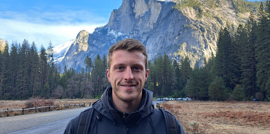 Foto von Clemens vor einem Berg. 