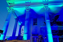 Haunted House Hier ist ein Haus, das blau angestrahlt ist und für Halloween dekoriert ist.
