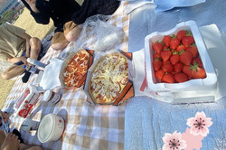 Hier sieht man Erdbeeren und zwei verschiedene Pizzen. 