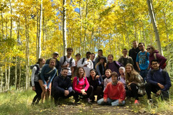 Eine Gruppe von Menschen stehen posieren in einem Wald für ein Foto.