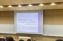Hier sieht man eine Leinwand in einem Hörsaal, auf der "Academic Orientation" geschrieben steht. 