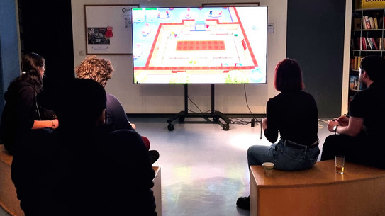 People sitting in front of a big screen playing video games.