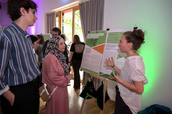 One of the exhibitors presents her project to two participants of the Global Gallery