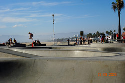 Venice Beach Das Bild zeigt den Blick auf einen Skatingpark und einen Strand im Hintergrund.