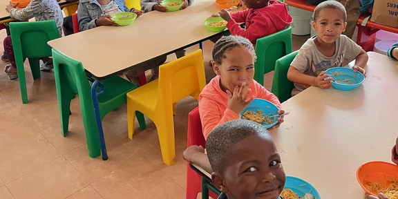 Children sitting at  tables and eating