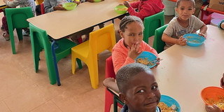 Children sitting at  tables and eating