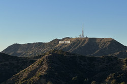 Der Schriftzug "Hollywood" inmitten von Bergen und blauem Himmel im Hintergrund. 