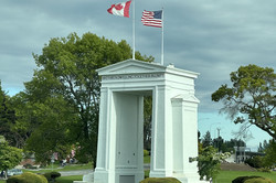 Hier sieht man ein Denkmal, auf dem die kanadische und amerikanische Flagge zu sehen sind.