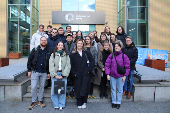 PROMOS Studienreise - Journalistik 2025 Eine Gruppe von Menschen steht vor einem Gebäude und schaut in die Kamera
