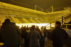 Menschen stehen im Inneren eines Fußballstadions.
