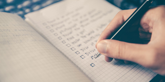 Checkliste Eine Person schreibt eine Checkliste