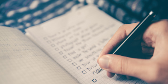 Eine Person schreibt eine Checkliste
