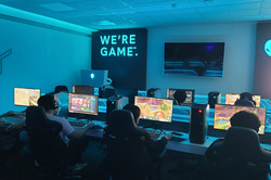 Gaming Room 1 Hier sieht man einen Raum, in dem viele Menschen an Bildschirmen sitzen und zocken.