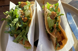 Zwei Tacos, gefüllt mit Salat auf einem Teller.