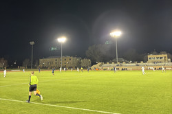 Männer spielen Fußball auf einem Fußballfeld bei Nacht