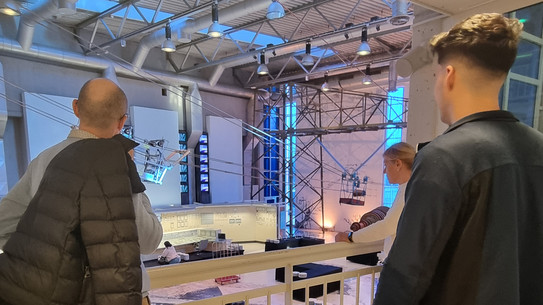 Menschen schauen in eine Industriehalle.