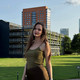 A photo of a young woman standing in front of a building.