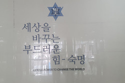 “Gentle Power to Change the world” der Slogan der Sookmyung abgebildet an einer Wand mit dem Logo der Universität.