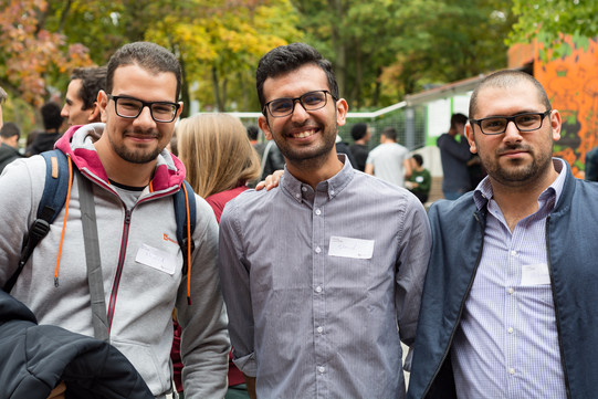 Drei internationale Studierende, die nebeneinander stehen und in die Kamera schauen