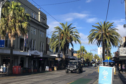 St Kilda Hier sieht man eine Straße, die von Palmen umsäumt ist.