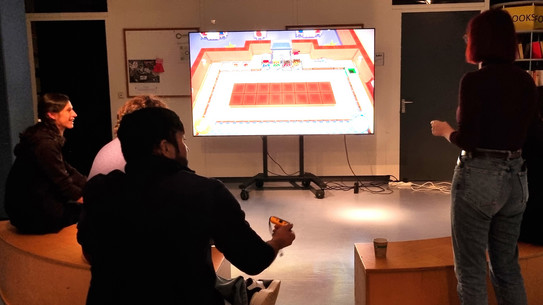 People sitting in front of a big screen playing video games.