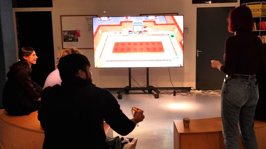 Menschen sitzen vor einem großen Bildschirm und spielen Videospiele.