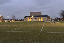 Ein Fußballplatz mit einem großen Gebäude im Hintergrund