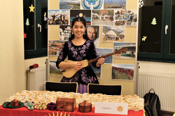 an Asian woman playing the guitar at the International CultureCafé (IKC)