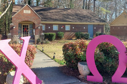 Haus einer Sorority Hier sieht man ein Wohnhaus und davor stehen griechische Buchstaben in pink.