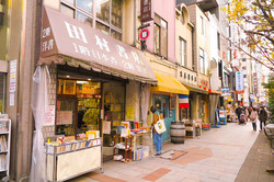 Jimbocho Man sieht ein Viertel von Tokyo. Es sind verschiedene kleine Läden zu sehen.