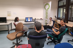 Menschen sitzen vor einem Bildschirm und spielen Videospiele.