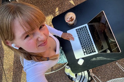 Nie ohne meinen Laptop Das Bild zeigt eine Person, die an ihrem Laptop arbeitet und an einem Tisch sitzt.