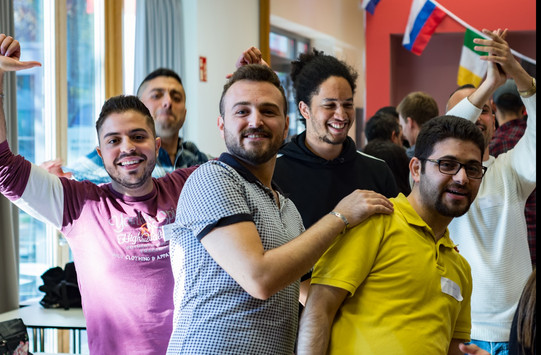 Eine Gruppe von Männern im Internationalen Begegnungszentrum der TU Dortmund, die lächelnd in die Kamera blickt
