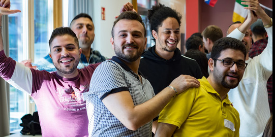 Come2Campus a group of men in the International Meeting Centre of the TU Dortmund University, smiling into the camera