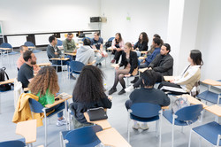 International students sit in two circles of chairs and talk.