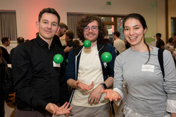 Three people with three small green balls
