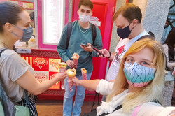 Harajuku Hier sieht man 4 Menschen mit Maske, die Essen am Spieß in der Hand halten.