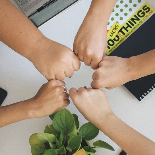 Diverse people hold their fists to each other as a sign of unity. 