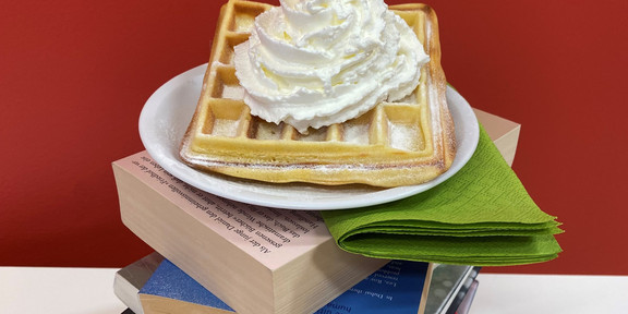 Waffle with cream on book tower