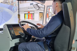 Ein Mann sitzt auf dem Sitz eines LKW-Simulators.